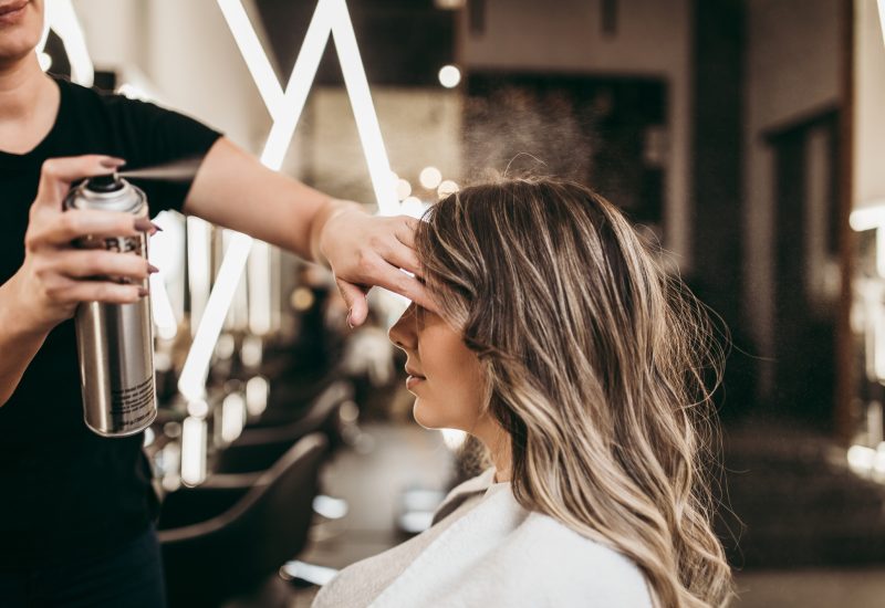 Beautiful brunette woman with long hair at the beauty salon getting a hair blowing. Hair salon styling concept.