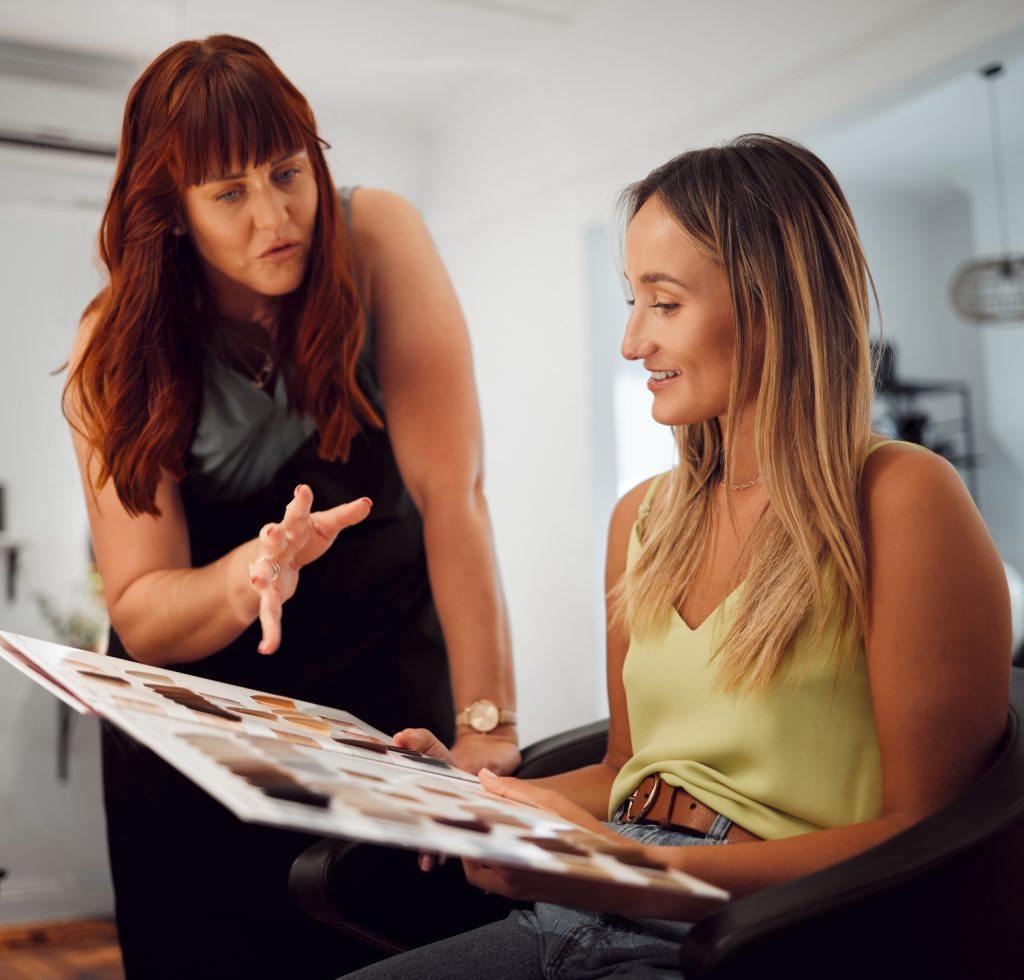 Salon, hair and and beauty with a woman customer at the hairdresser with a stylist choosing a color. Fashion, studio and client with a young female getting a haircut in a professional boutique